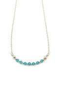 Aqua Bloom Necklace - Faceted blue beads centered on a delicate silver chain.
