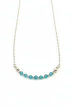 Aqua Bloom Necklace - Faceted blue beads centered on a delicate silver chain.