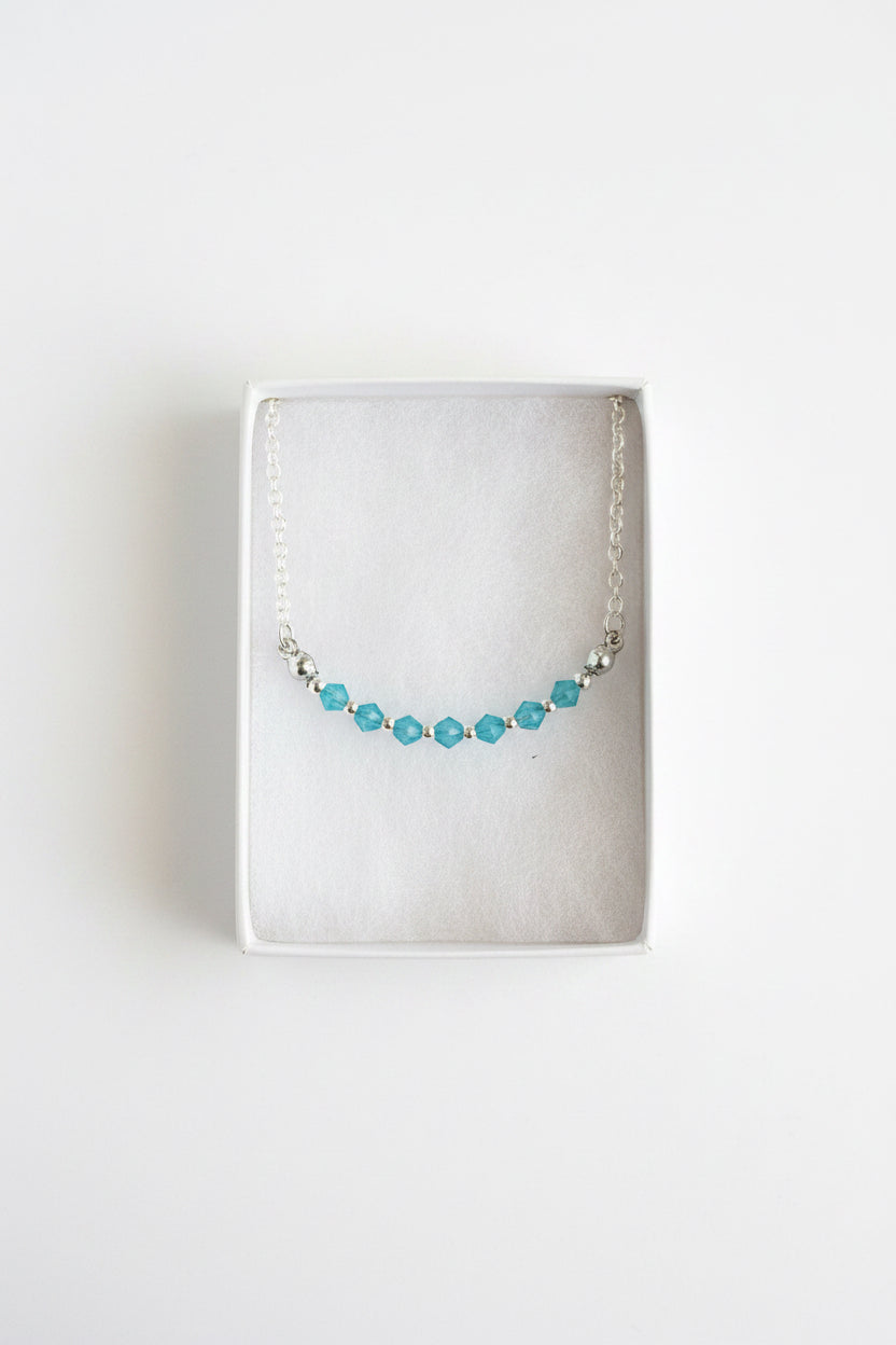 Bracelet with blue beads in a cardboard box