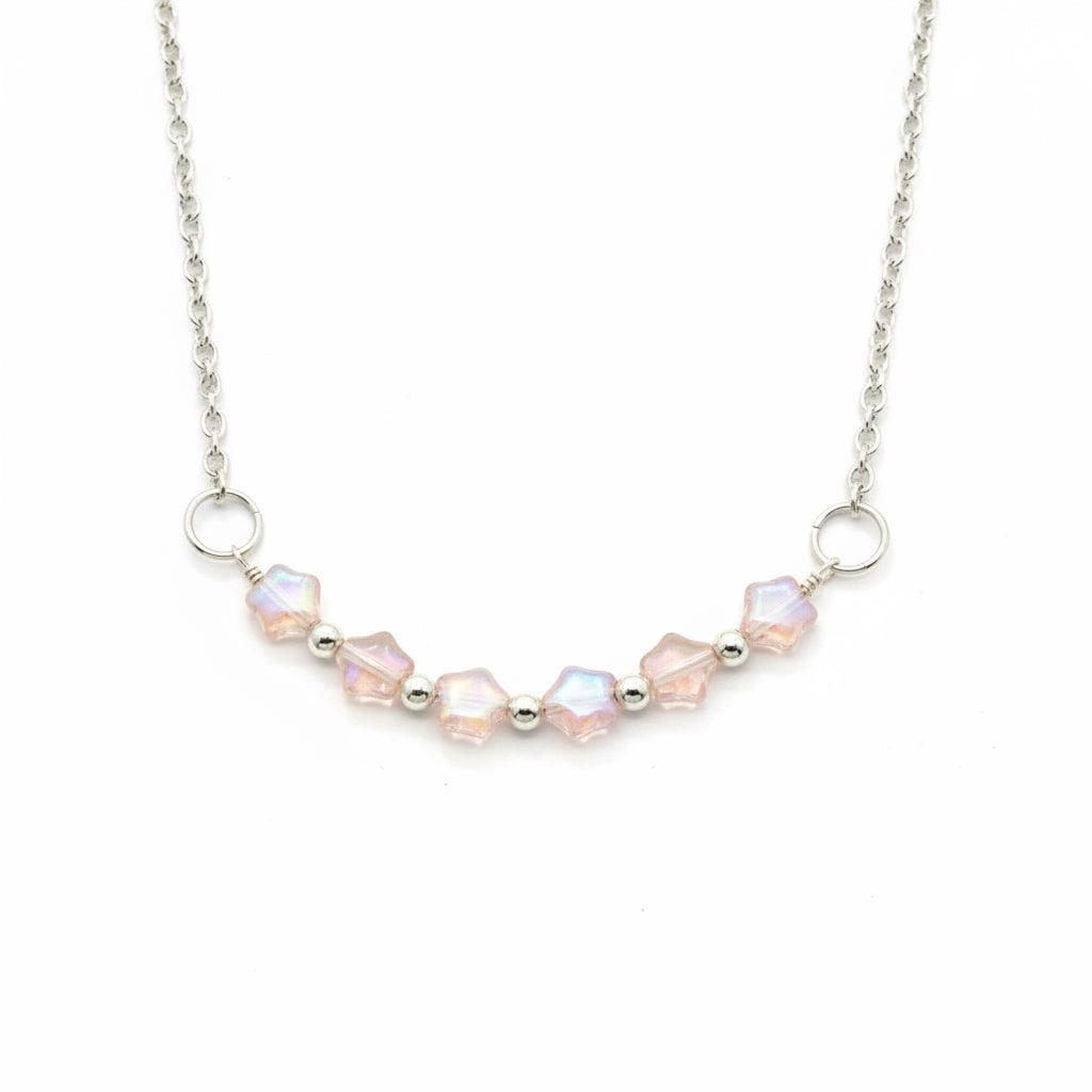 A silver chain necklace featuring a curved row of faceted iridescent beads in soft pink and white, separated by small silver spacer beads, with two silver O-ring connectors, shown on a plain white background.