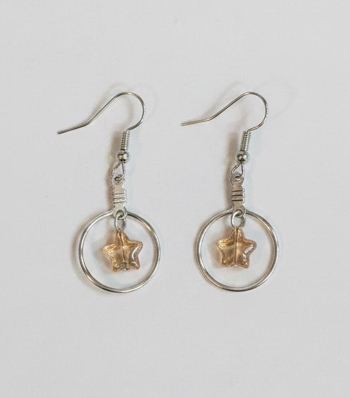 A pair of silver-toned dangle earrings with circular hoops and small starfish charms, shown on a plain light background.