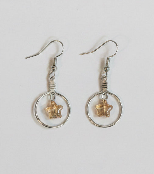 A pair of silver-toned dangle earrings with circular hoops and small starfish charms, shown on a plain light background.