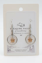 Treasure Valley Creations handmade dangle earrings with silver-toned circular hoops, wrapped wire, and star-shaped amber pendants, displayed on a branded white backing card.