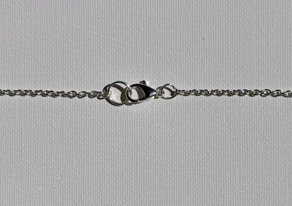 Round metallic necklace clasp on a white background