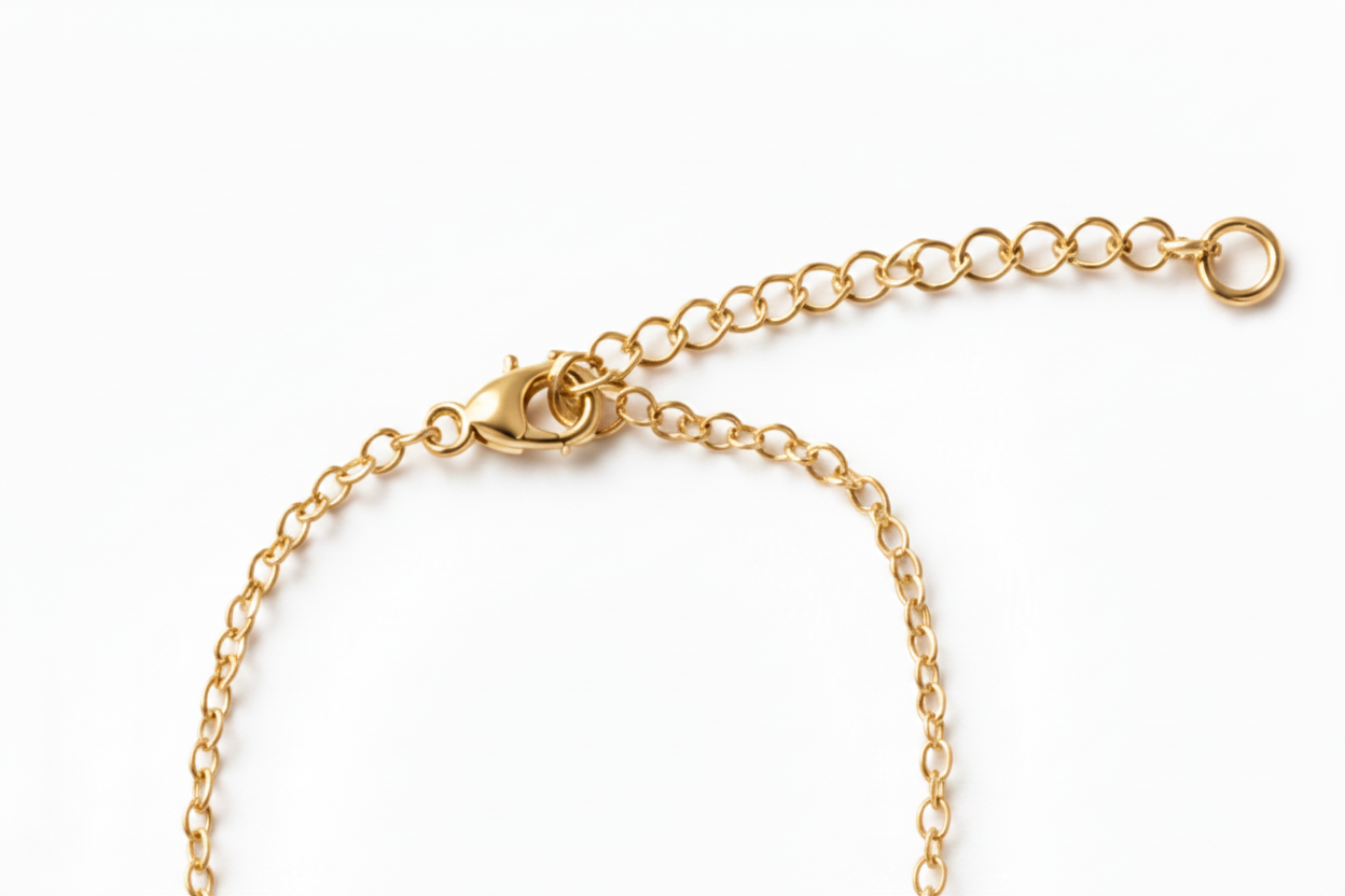A close-up of a gold chain necklace showing the lobster clasp, extender chain, and ring closure on a plain white background.