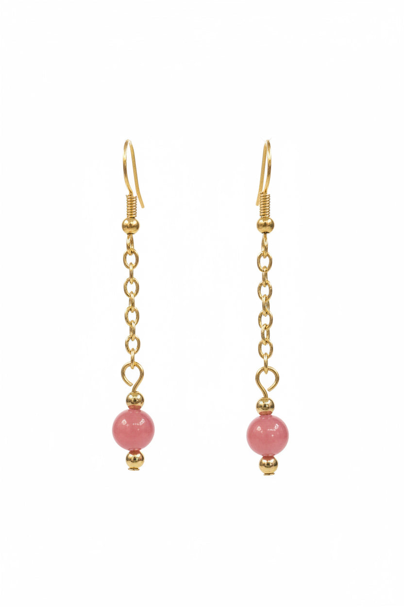 Gold dangle earrings with a small pink bead at the bottom, displayed against a black background.