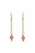 Gold dangle earrings with a small pink bead at the bottom, displayed against a black background.