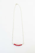 Necklace with red beads on a white background