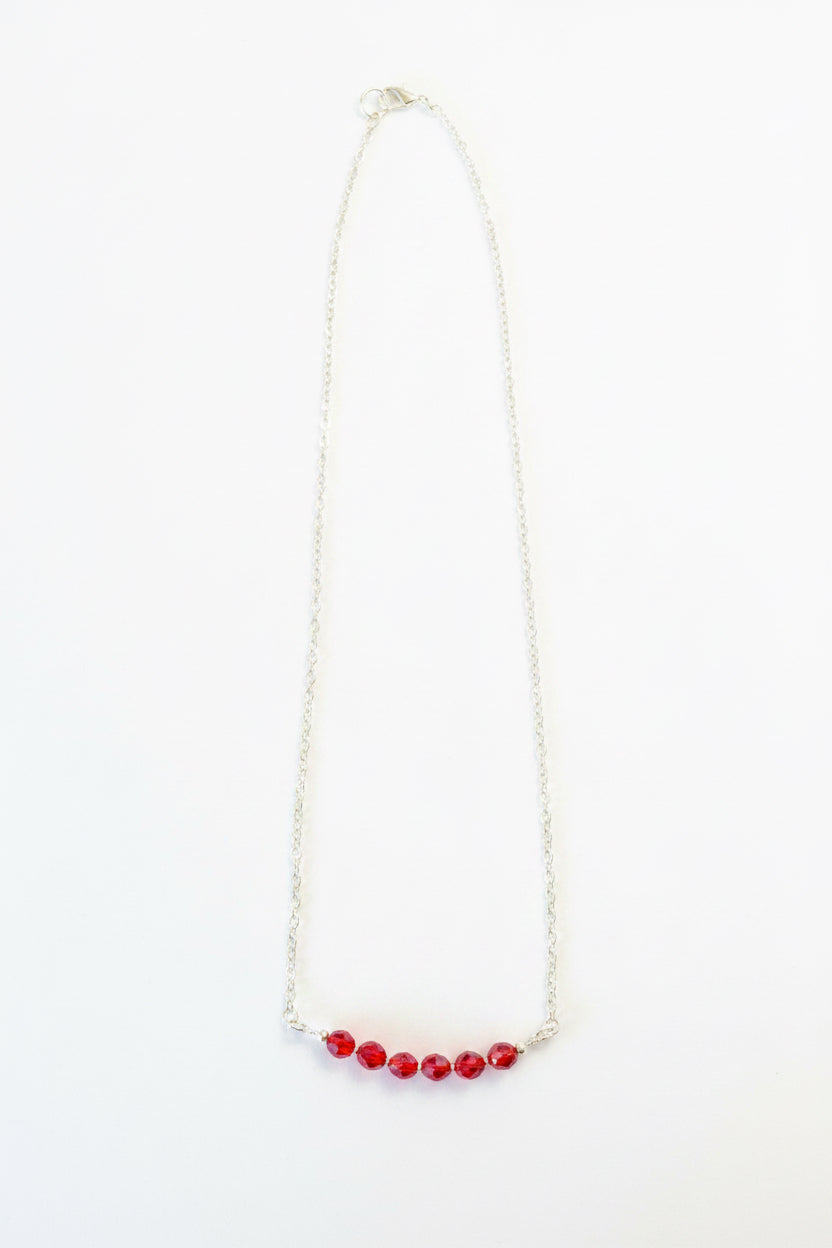 Necklace with red beads on a white background