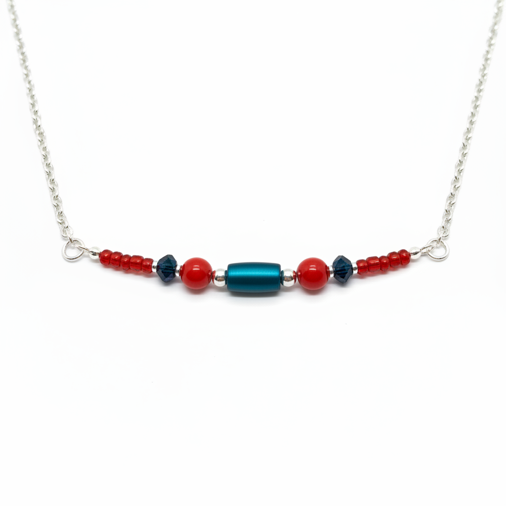 A silver beaded necklace featuring a central turquoise blue faceted bead flanked by red and black faceted beads, displayed on a clean white background.