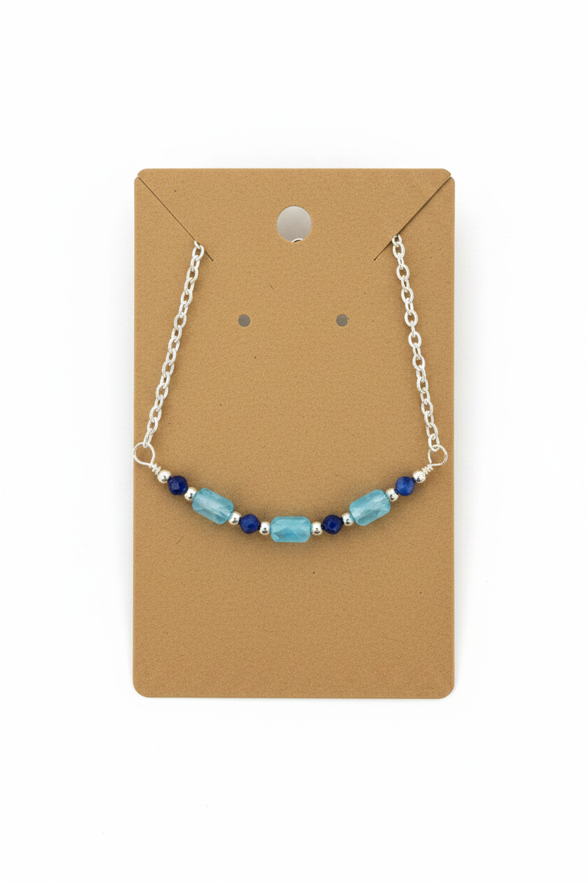 Bracelet with blue and silver beads on a brown card