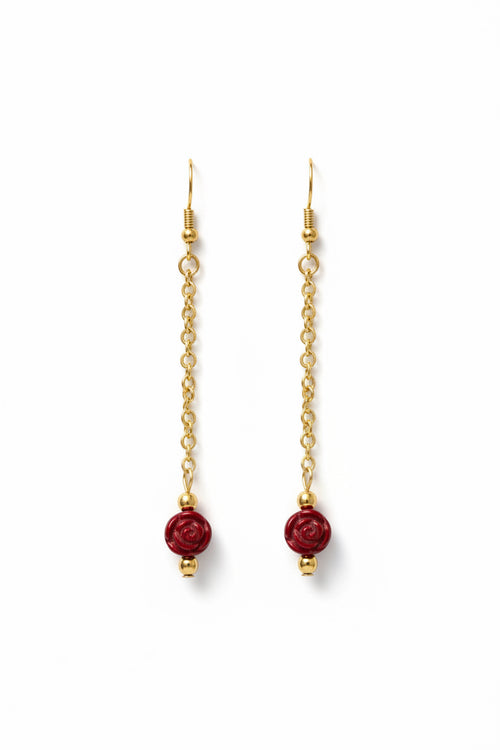 Gold chain earrings with red beads on a white background