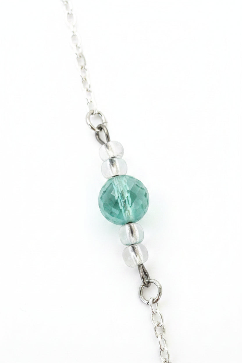 Close-up of a necklace with a green bead