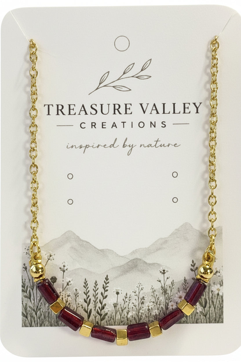 Treasure Valley Creations gold chain necklace with rectangular garnet and gold-tone cube beads, displayed on its branded jewelry card.