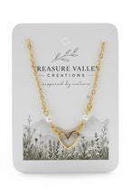 A gold chain necklace with a heart-shaped pendant and small pearl beads, displayed on a white card from Treasure Valley Creations.