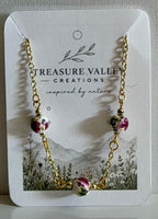 Treasure Valley Creations gold chain necklace with three pink and green floral bead charms, displayed on its white branded card.