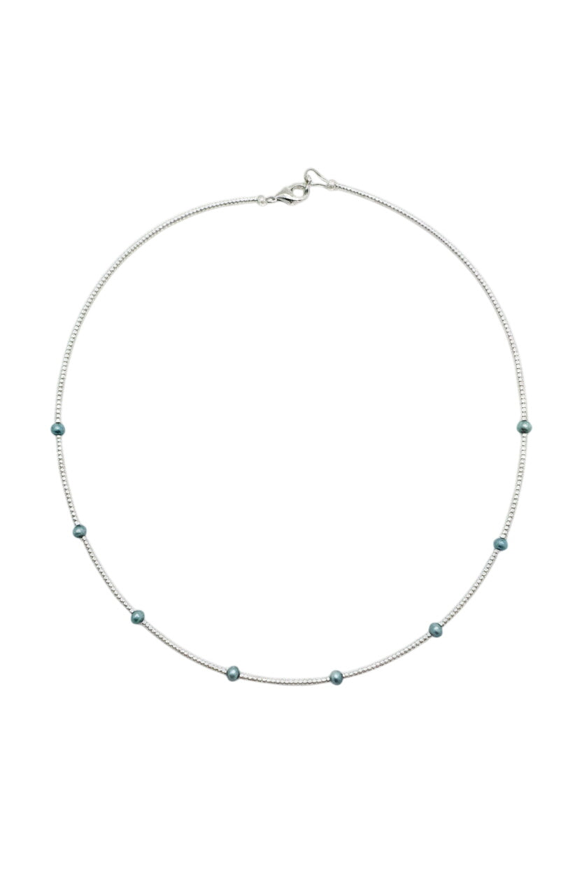 Necklace with small beads on a beige fabric background