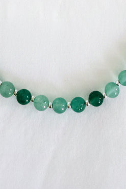 Green beaded necklace on a white background