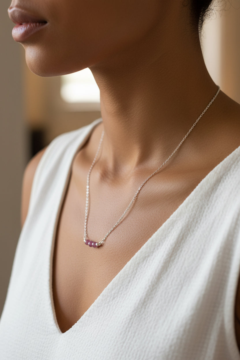 Necklace with a pendant worn by a person in a white top, blurred background