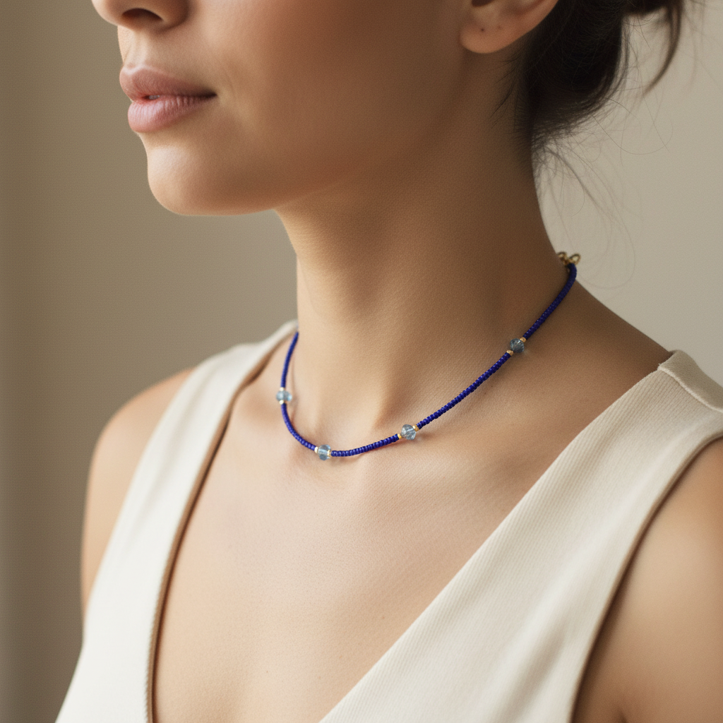 Woman wearing a blue beaded necklace against a neutral background