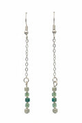 A pair of long silver-toned dangle earrings with chain links and small beads, including green faceted beads and pale mint beads, displayed on a black background.