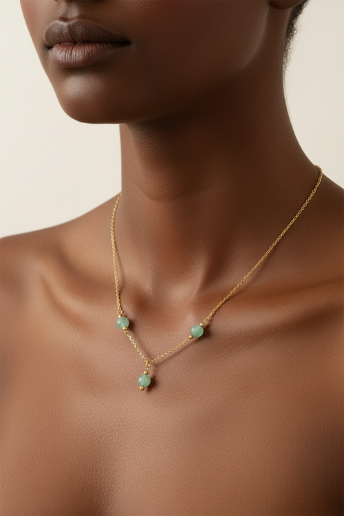 Delicate handmade gold-tone necklace with three pale green round beads and a small center drop pendant.