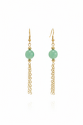 A pair of gold dangle earrings featuring a smooth, light green round bead and a delicate gold chain dangle, shown against a plain white background with a faint reflection below.