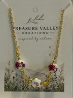 Treasure Valley Creations gold chain necklace with three floral ceramic beads, displayed on its branded card backing.