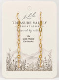 Treasure Valley Creations 18k gold-plated ear hooks on a cream-colored display card with a botanical and mountain illustration.