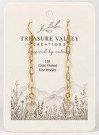Treasure Valley Creations 18k gold-plated ear hooks on a cream-colored display card with a botanical and mountain illustration.