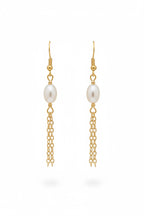 A pair of gold dangle earrings with a white freshwater pearl and a dangling chain, shown on a plain white background.