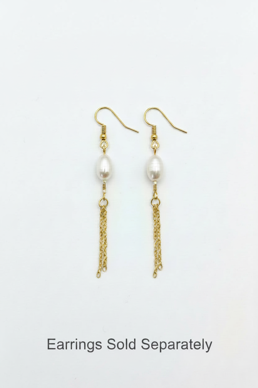 Gold earrings with pearls on a light gray background