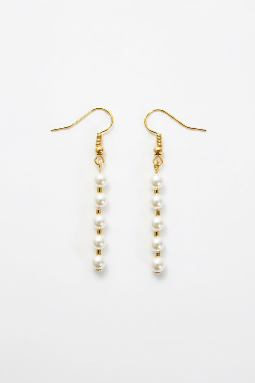 A pair of gold-tone dangle earrings with small white pearl beads, displayed on a clean white background.