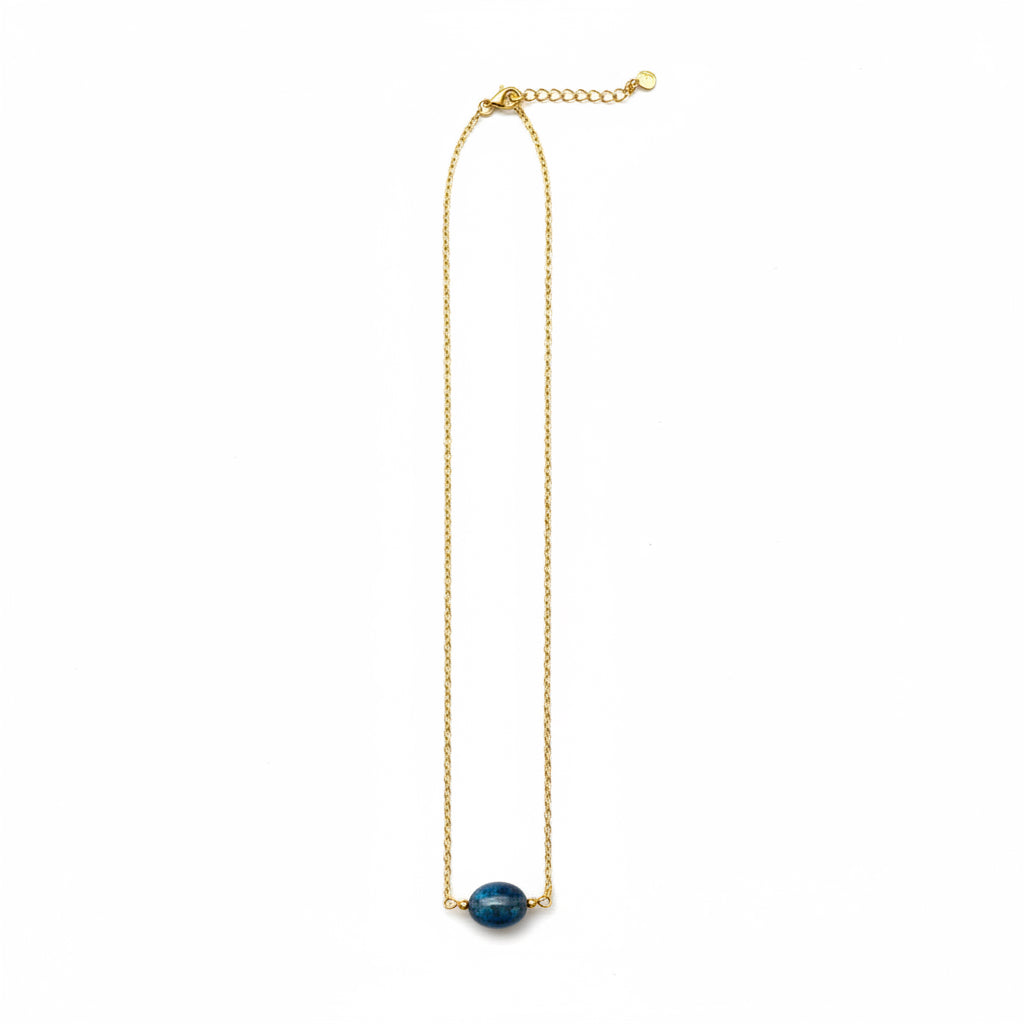 A delicate gold chain necklace featuring a single oval dark blue stone pendant, displayed against a solid white background.