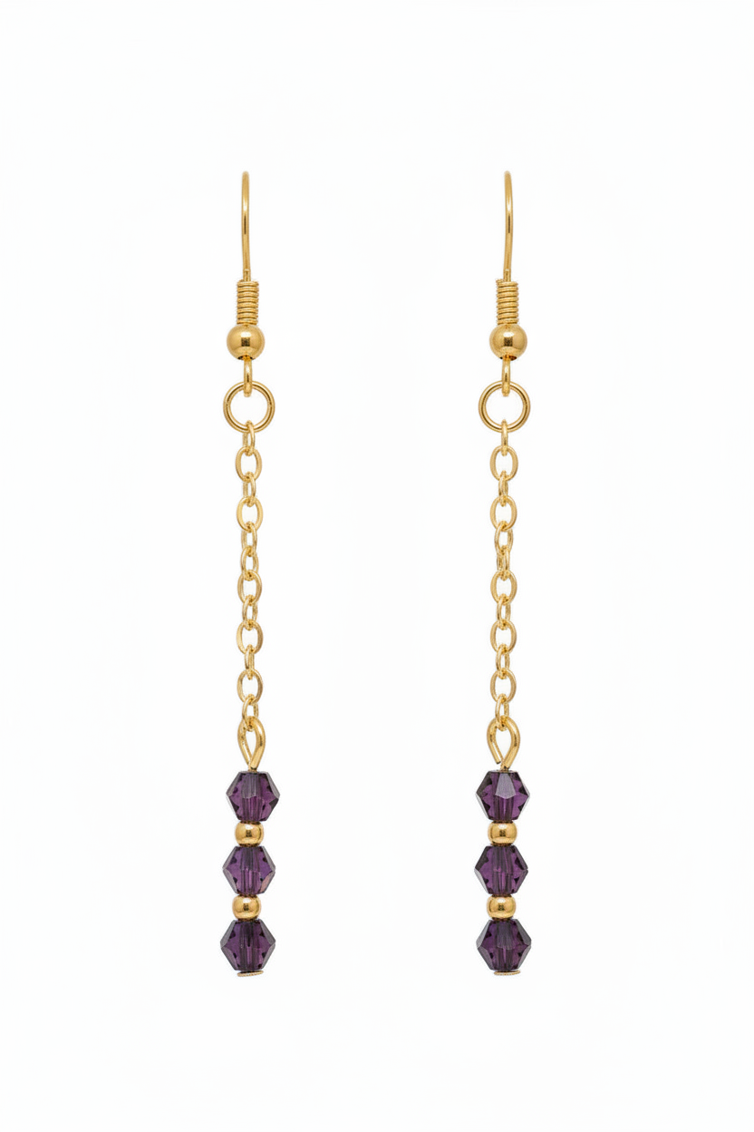A pair of gold dangle earrings with three faceted purple beads at the bottom, shown against a plain white background.