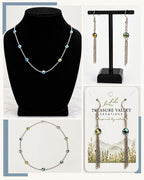 A jewelry set displayed in a collage: a silver beaded necklace on a black mannequin bust, matching drop earrings on a black stand, and the necklace and earrings on a branded card. The jewelry features iridescent blue, green, and yellow beads with silver chain links.