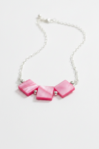 A silver chain necklace featuring three pink mother-of-pearl square beads separated by small silver spacer beads, displayed on a clean white background.