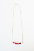 Necklace with red beads on a white background