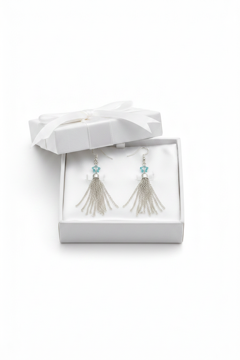Pair of tassel earrings in a white jewelry box on a white background