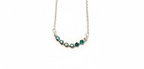 A silver-toned necklace featuring a curved bar of faceted gemstones in shades of green and dark blue, suspended on a delicate silver chain against a plain white background.