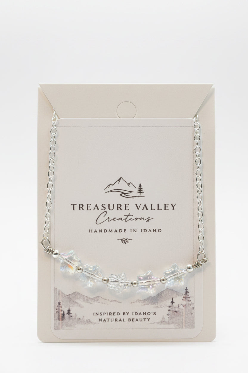 Treasure Valley Creations handmade silver necklace with star-shaped beads, displayed on its original cream-colored backing card.
