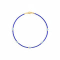 Blue beaded necklace with gold clasp on a white background