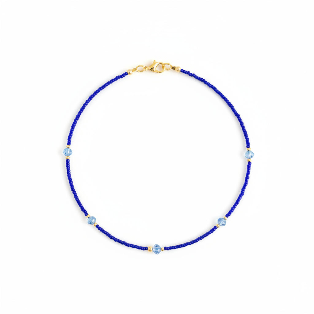 Blue beaded necklace with gold clasp on a white background