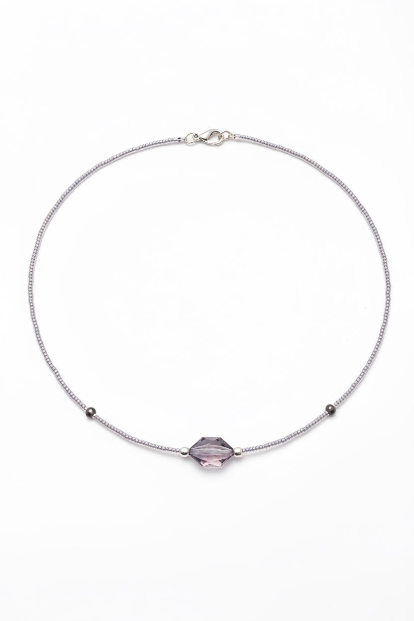 Necklace with a purple gemstone on a white background