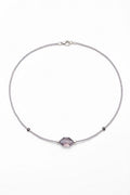 Necklace with a purple gemstone on a white background
