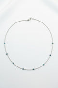 Necklace with small beads on a beige fabric background