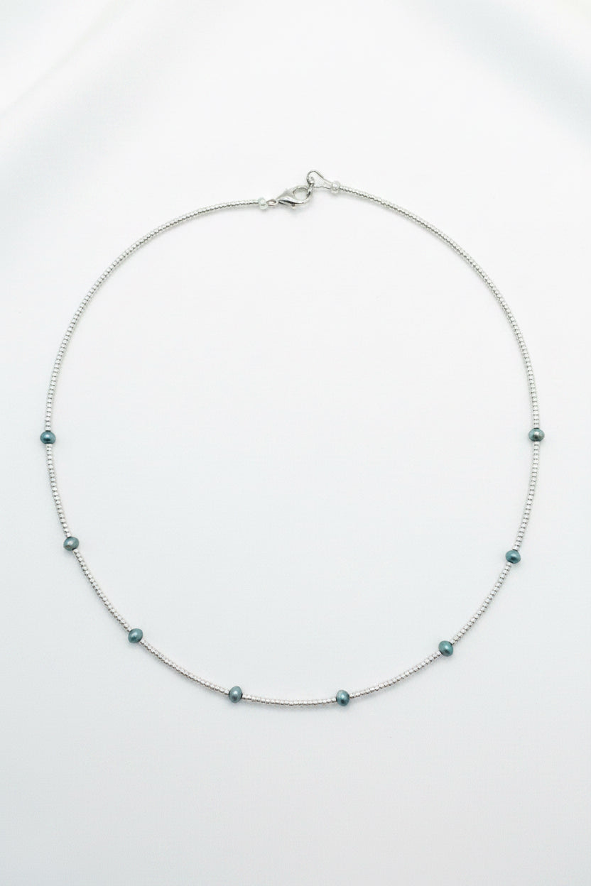 Necklace with small beads on a beige fabric background