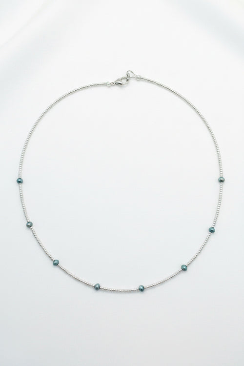 Necklace with small beads on a beige fabric background