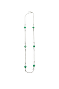Necklace with green beads on a white fabric background