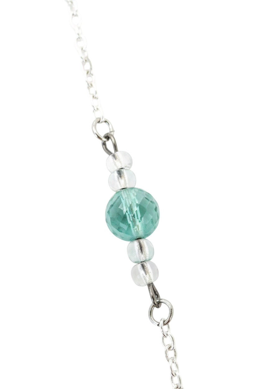 Close-up of a necklace with a green bead